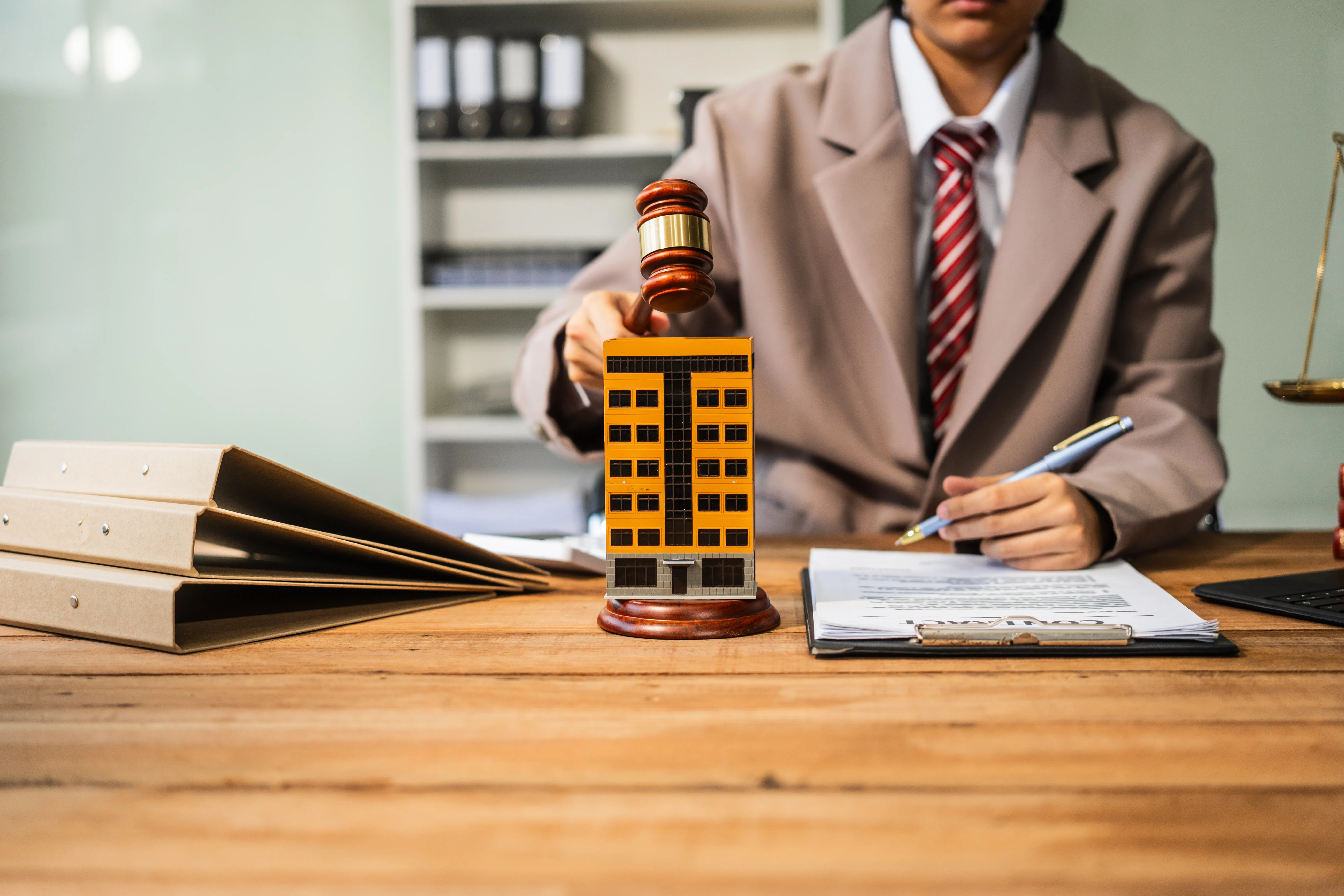 a young woman holding a gavel on top of a yellow building model